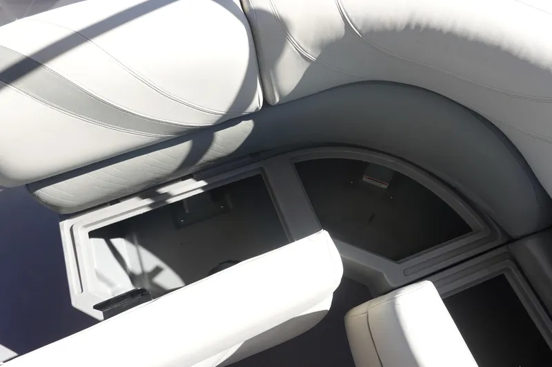 Slide: The Image of 2018 Sylvan Mirage 8522 boat interior storage compartments with white cushioned seating. - 14