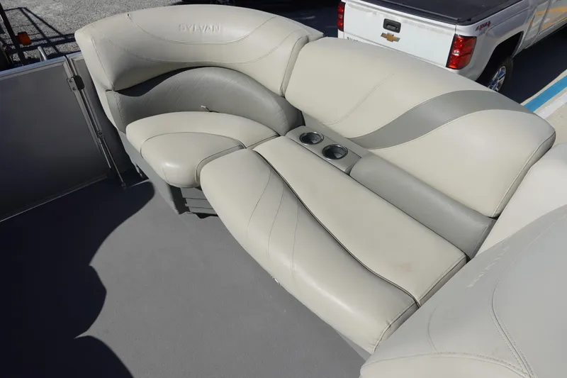 Slide: The Image of 2018 Sylvan Mirage 8522 boat interior with beige seating and cup holders. - 18