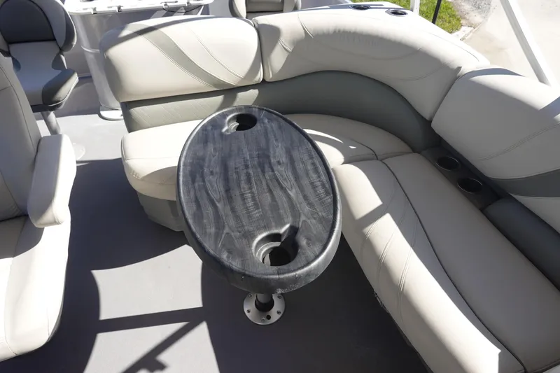 Slide: The Image of 2018 Sylvan Mirage 8522 boat interior with cushioned seating and oval table. - 20