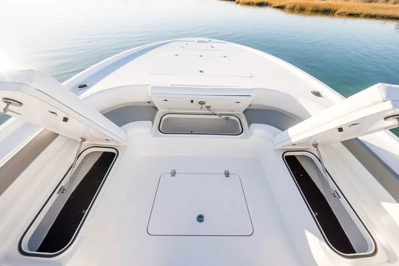 Slide: The Image of Caymas 281 HB 2026 boat with open storage compartments on calm water. - 10