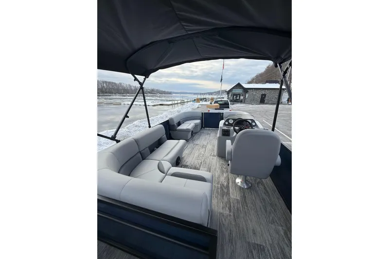 Slide: The Image of 2026 Bentley Pontoons 200 Fish-N-Cruise interior with seating and helm, docked by snowy shore. - 5