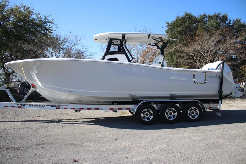 Slide: The Image of 2026 Tidewater 302 CC Adventure boat on trailer, parked outdoors. - 0