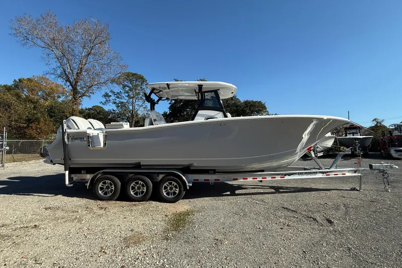 Slide: The Image of 2026 Tidewater 302 CC Adventure boat on a trailer, parked outdoors. - 11