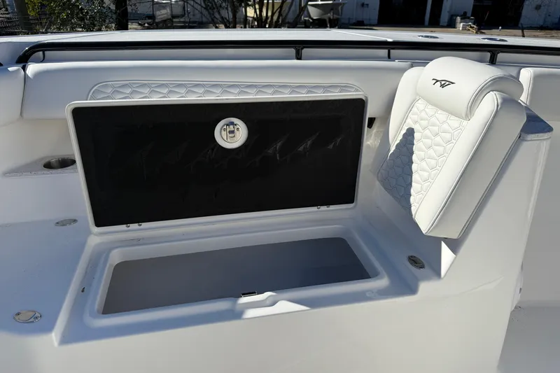 Slide: The Image of 2026 Tidewater 302 CC Adventure boat interior with storage compartment and cushioned seating. - 14