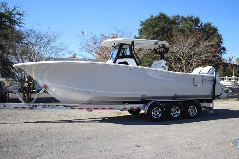 Slide: The Image of 2026 Tidewater 302 CC Adventure boat on trailer, parked outdoors. - 2