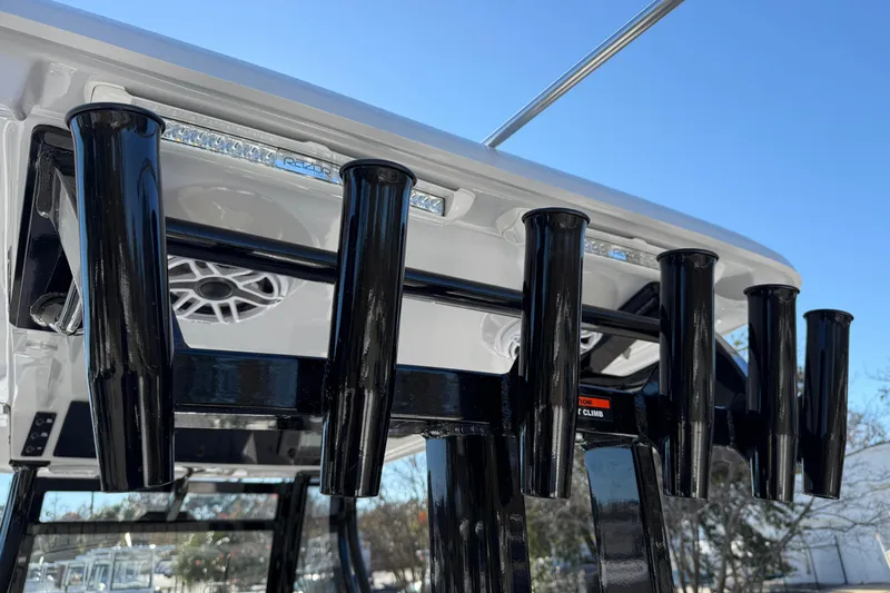 Slide: The Image of Rod holders on a 2026 Tidewater 302 CC Adventure boat under a clear blue sky. - 24