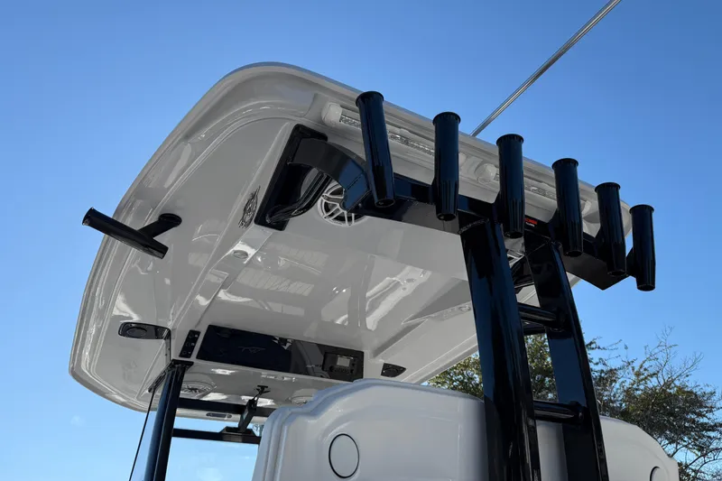 Slide: The Image of Tidewater 302 CC Adventure 2026 boat with rod holders and T-top against blue sky. - 25