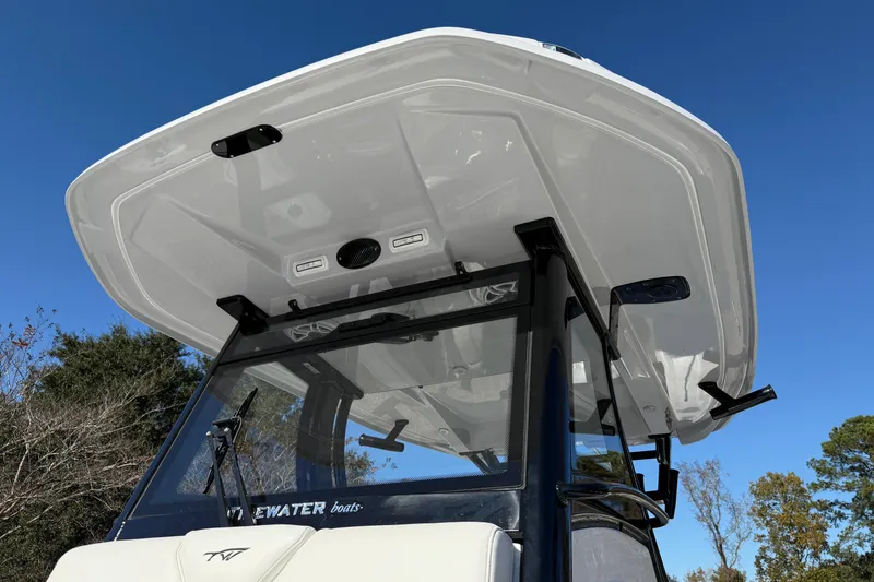 Slide: The Image of 2026 Tidewater 302 CC Adventure boat with sleek hardtop against clear blue sky. - 26