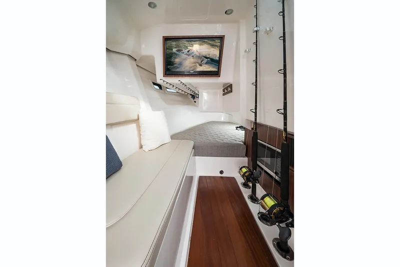 Slide: The Image of Manufacturer Provided Image: 2018 Pursuit DC 365 Dual Console cabin interior with fishing rods and seating. - 11