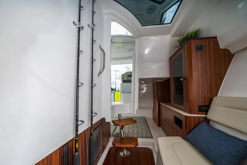 Slide: The Image of Manufacturer Provided Image: Interior of 2018 Pursuit DC 365 Dual Console boat with wooden accents and fishing rods. - 15
