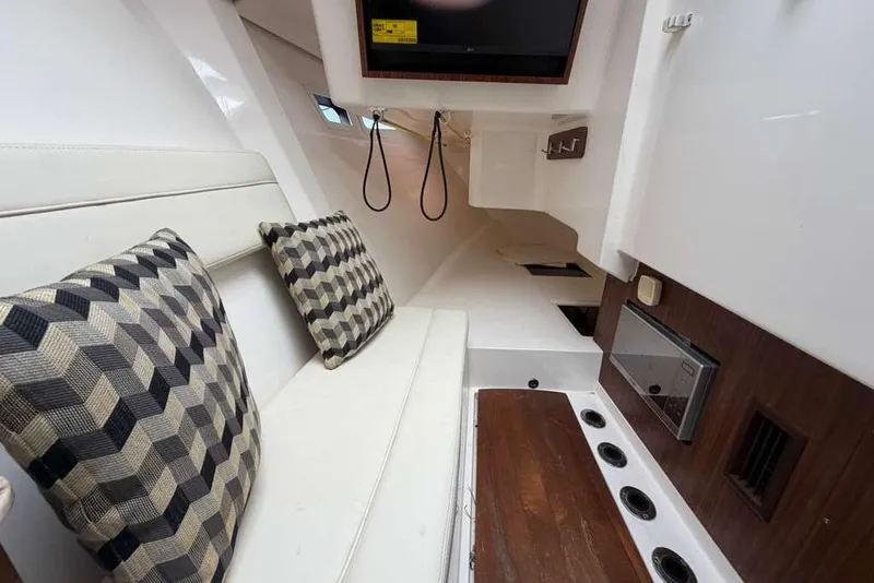 Slide: The Image of Interior of 2018 Pursuit DC 365 Dual Console with cushioned seating and patterned pillows. - 16