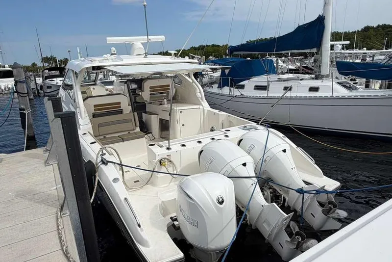 Slide: The Image of 2018 Pursuit DC 365 Dual Console boat docked with triple outboard engines. - 21