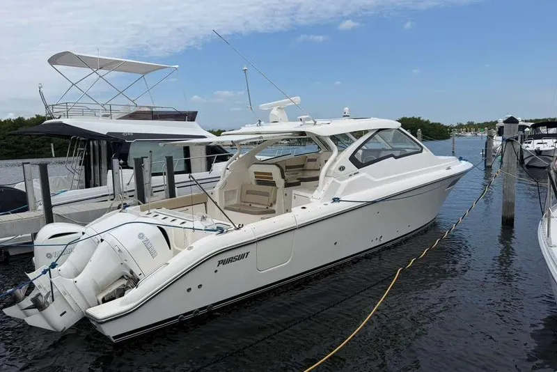 Slide: The Image of 2018 Pursuit DC 365 Dual Console boat docked at marina, side view. - 24
