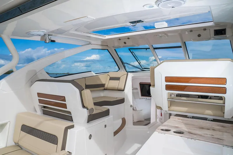 Slide: The Image of Manufacturer Provided Image: Interior of 2018 Pursuit DC 365 Dual Console boat with luxurious seating and panoramic windows. - 5