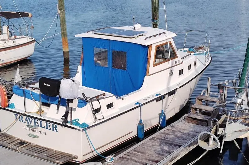 Slide: The Image of 1987 Albin Family Cruiser docked, featuring blue canopy and solar panel. - 2