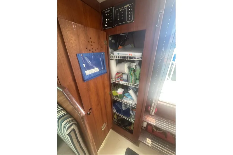 Slide: The Image of 1987 Albin Family Cruiser interior storage with shelves and cleaning supplies. - 20