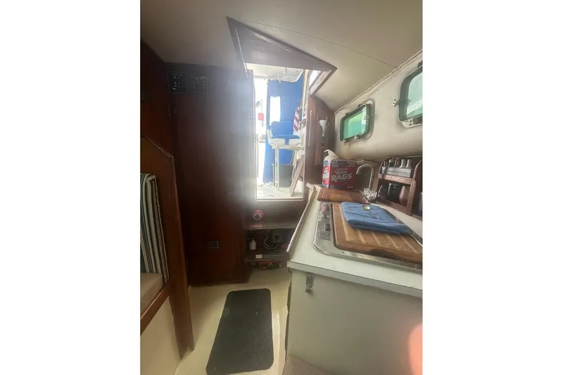 Slide: The Image of Interior of 1987 Albin Family Cruiser with kitchenette and wooden cabinetry. - 25