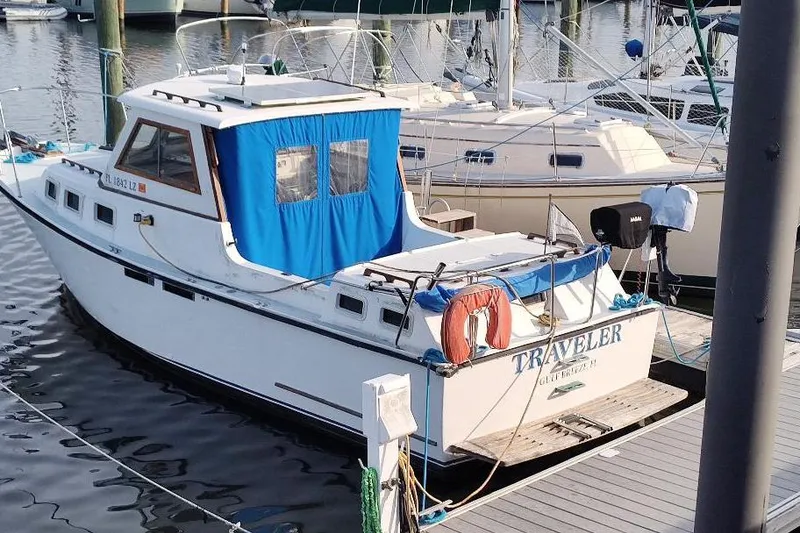 Slide: The Image of 1987 Albin Family Cruiser docked at marina with blue canopy and lifebuoy. - 4