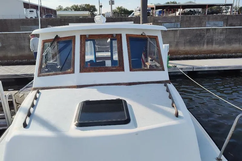 Slide: The Image of 1987 Albin Family Cruiser docked at marina, front view with windows and hatch. - 5