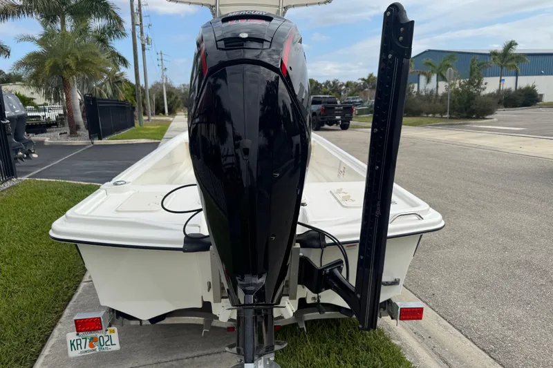 Slide: The Image of 2017 Mako Pro Skiff 19 CC with Mercury outboard motor, parked on a street. - 11