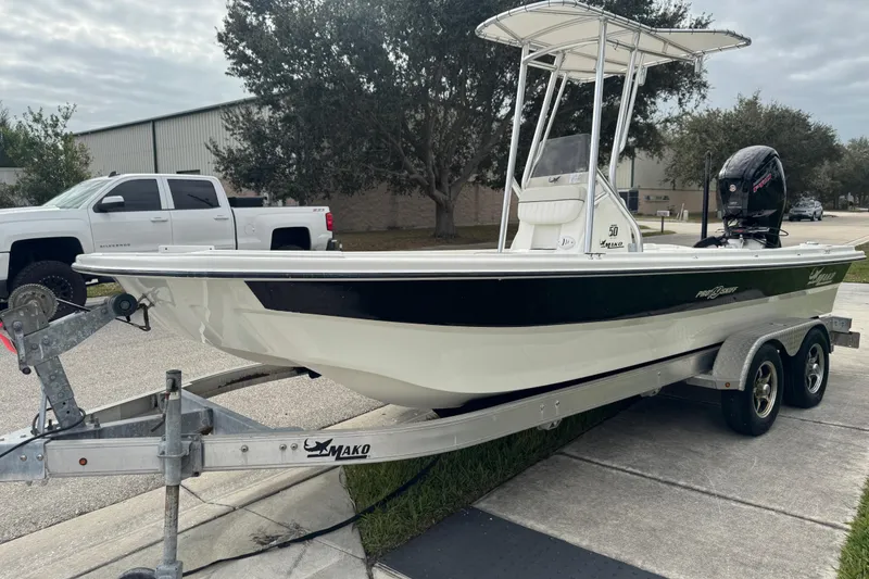 Slide: The Image of 2017 Mako Pro Skiff 19 CC boat on trailer, parked outdoors. - 21