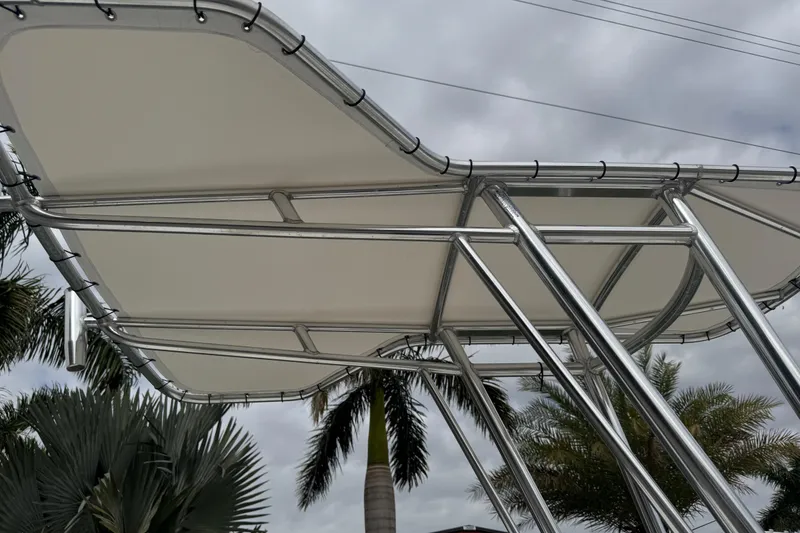 Slide: The Image of 2017 Mako Pro Skiff 19 CC T-top with palm trees and cloudy sky background. - 37