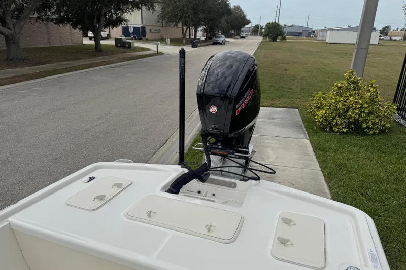 Slide: The Image of 2017 Mako Pro Skiff 19 CC boat with outboard motor on a residential street. - 58