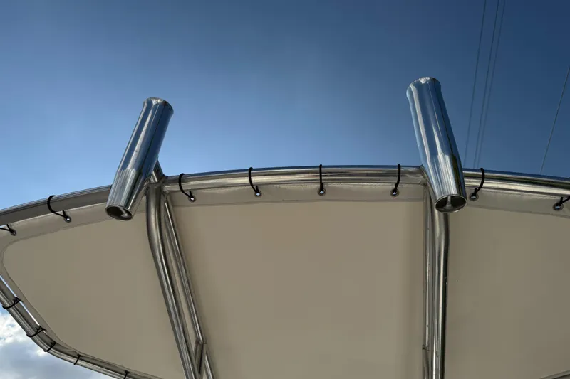 Slide: The Image of 2017 Mako Pro Skiff 19 CC boat canopy with rod holders against blue sky. - 68