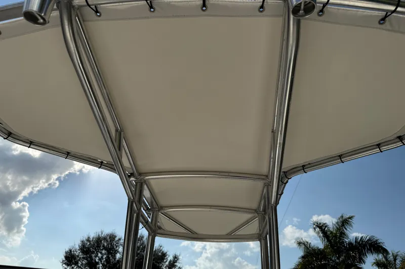 Slide: The Image of 2017 Mako Pro Skiff 19 CC T-top under sunny sky with palm trees. - 69