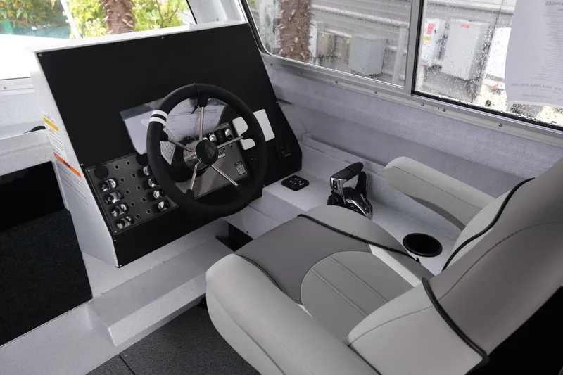 Slide: The Image of 2026 KingFisher 2825 Coastal Express boat interior with steering wheel and control panel. - 13
