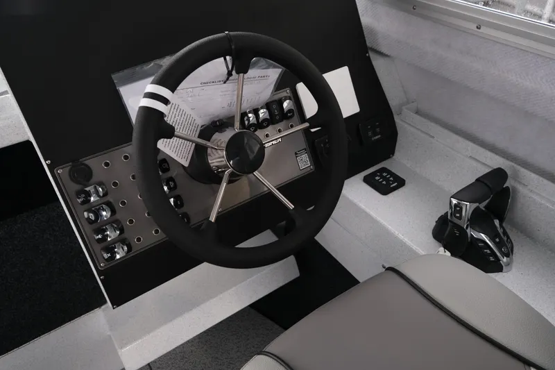 Slide: The Image of 2026 KingFisher 2825 Coastal Express boat dashboard with steering wheel and controls. - 14