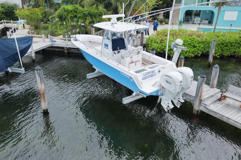 Slide: The Image of 2024 Contender 30 Tournament boat docked with dual Yamaha engines, named "Latitude Adjustment." - 2