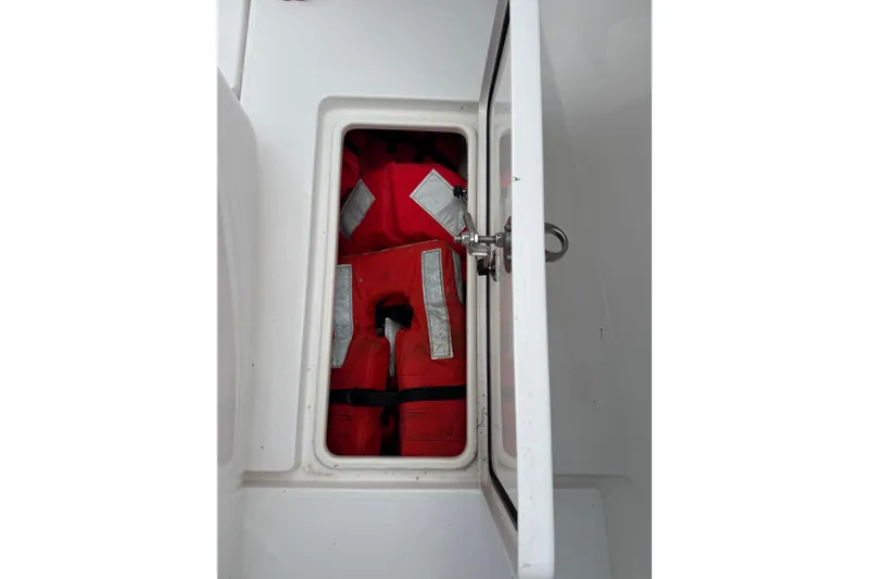 Slide: The Image of Storage compartment with red life jackets on a 2024 Contender 30 Tournament boat. - 26