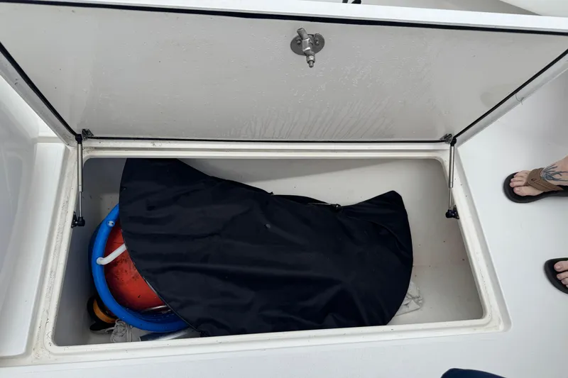 Slide: The Image of Open storage compartment on 2024 Contender 30 Tournament boat with various items inside. - 27