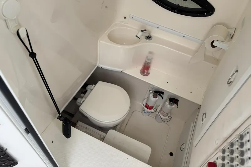 Slide: The Image of 2024 Contender 30 Tournament boat bathroom with toilet, sink, and fire extinguishers. - 33