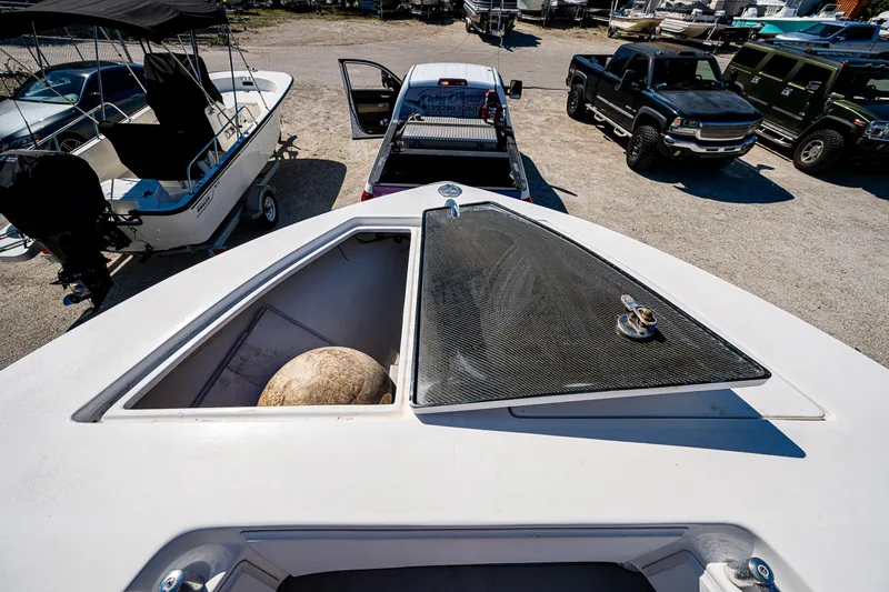 Slide: The Image of 2015 SeaHunter 37 Tournament boat with open storage compartment, parked near trucks. - 17