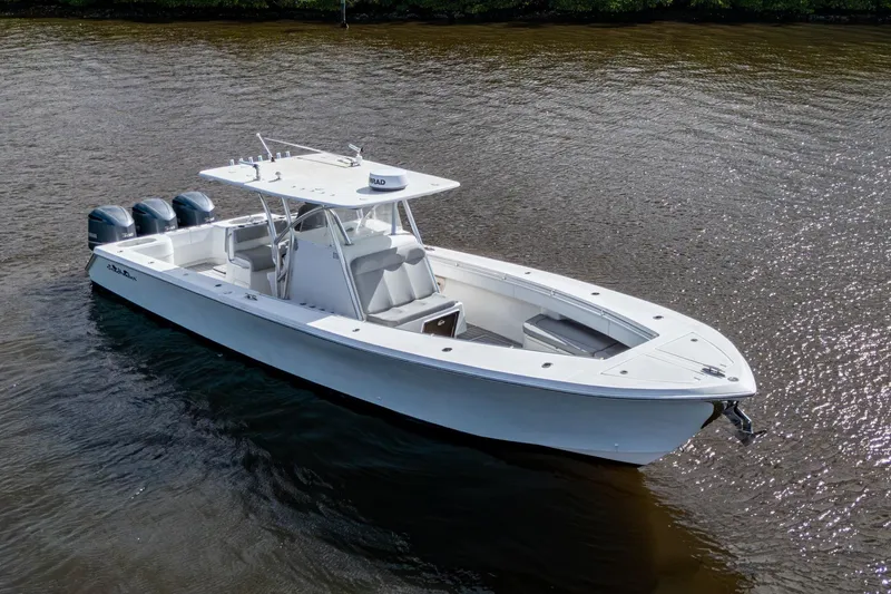 Slide: The Image of 2015 SeaHunter 37 Tournament boat on calm water, featuring triple outboard engines. - 23