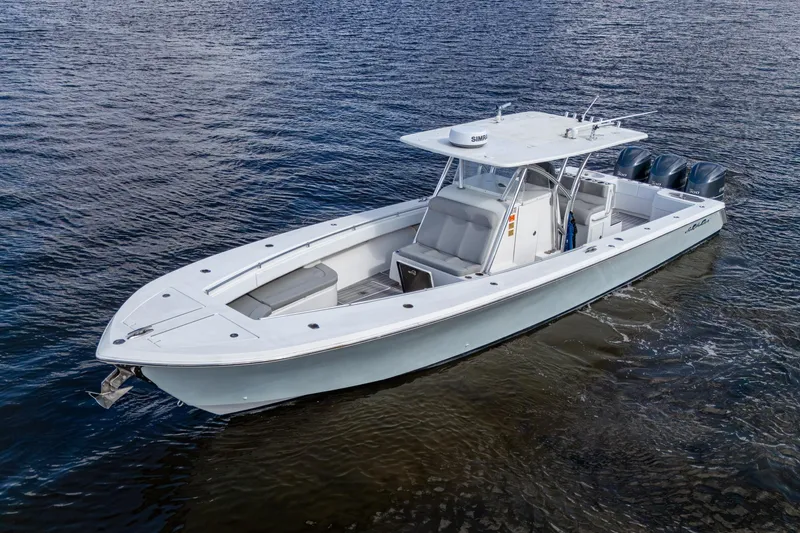 Slide: The Image of 2015 SeaHunter 37 Tournament boat on water, featuring sleek design and triple outboard engines. - 26
