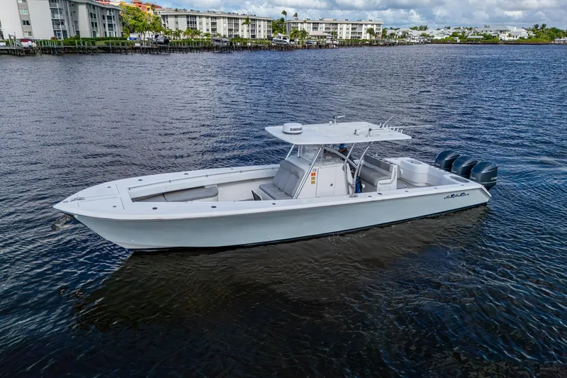 Slide: The Image of 2015 SeaHunter 37 Tournament boat on calm water near residential buildings. - 28