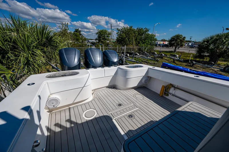 Slide: The Image of 2015 SeaHunter 37 Tournament boat deck with triple outboard motors, under a clear blue sky. - 9