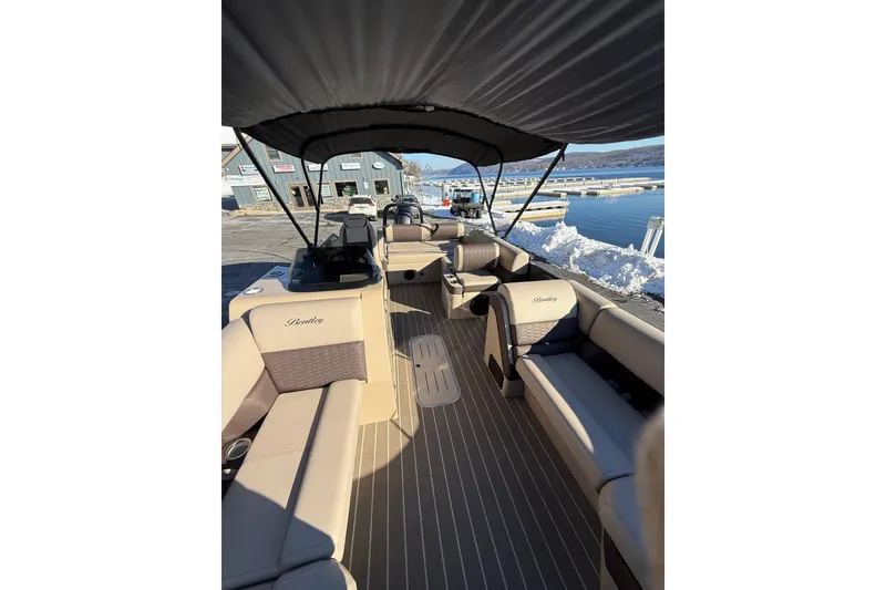 Slide: The Image of 2026 Bentley Pontoons Elite 223 Swingback Bench on snowy dock, showcasing luxurious seating. - 11