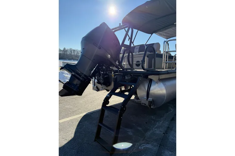 Slide: The Image of 2026 Bentley Pontoons Elite 223 Swingback Bench with outboard motor and ladder in sunlight. - 3