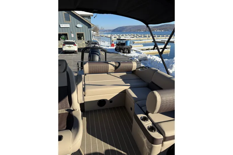 Slide: The Image of 2026 Bentley Pontoons Elite 223 Swingback Bench with luxurious seating and scenic waterfront view. - 7