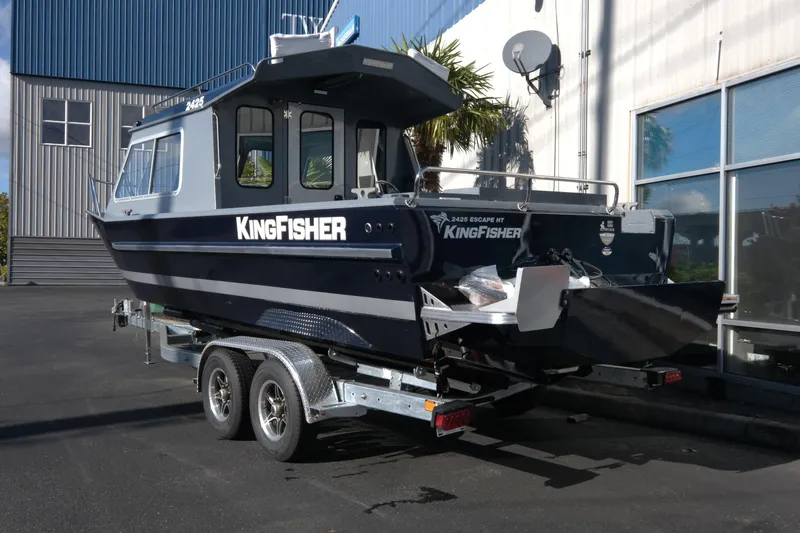 Slide: The Image of 2026 KingFisher 2425 Escape HT boat on trailer, parked outside a building. - 4