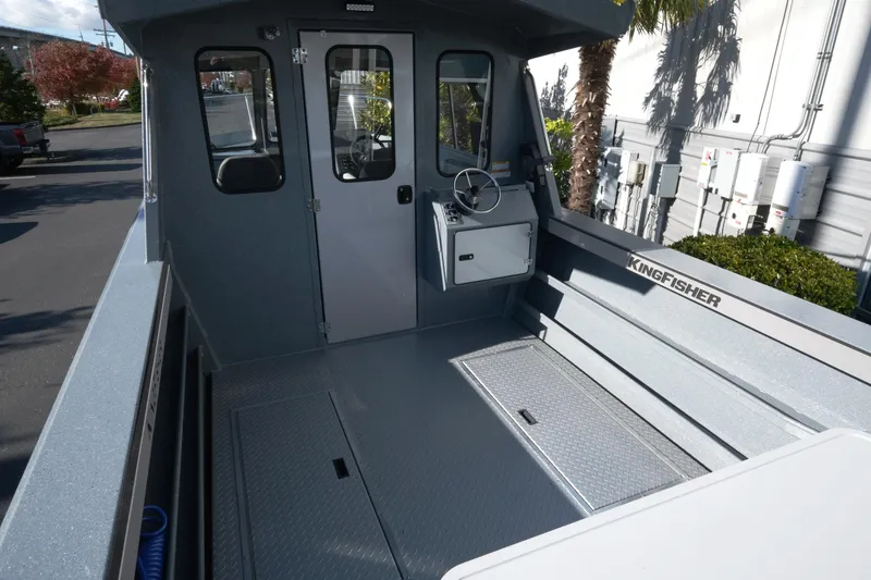 Slide: The Image of 2026 KingFisher 2425 Escape HT boat interior with steering console and seating area. - 7