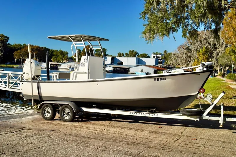 The Image of 1970 Aquasport 222 Flatback boat on trailer by a lakeside dock. - 0