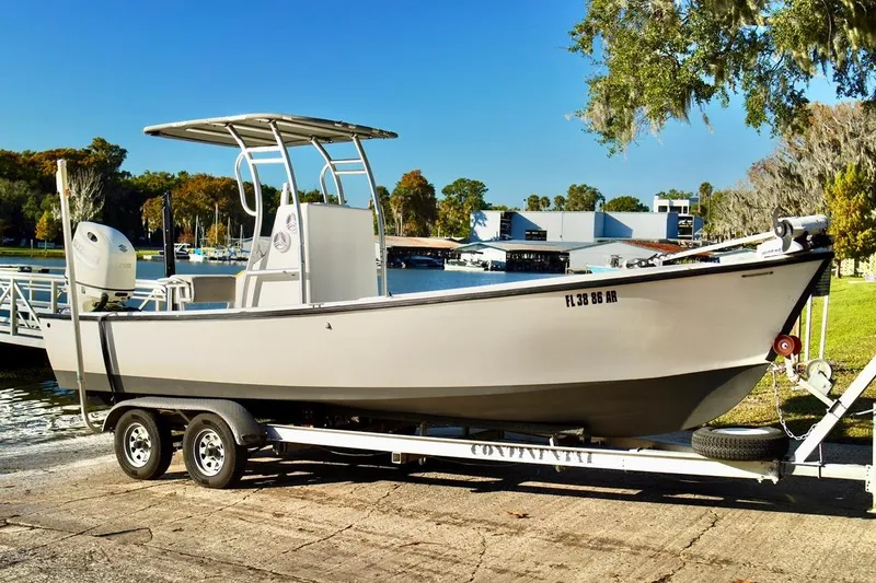 Slide: The Image of 1970 Aquasport 222 Flatback boat on trailer by a scenic waterfront. - 1