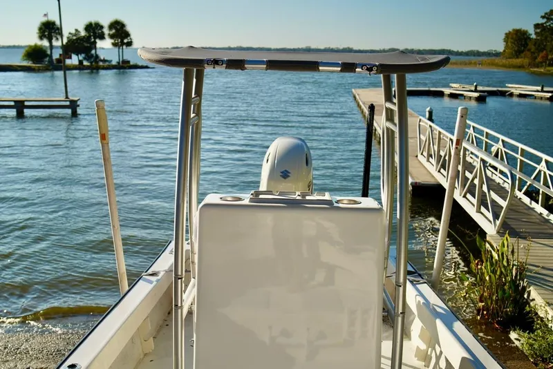 Slide: The Image of 1970 Aquasport 222 Flatback boat docked by a serene lake under clear skies. - 10