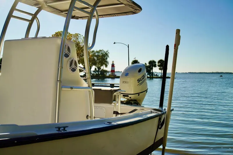 Slide: The Image of 1970 Aquasport 222 Flatback boat with Suzuki motor near a scenic lighthouse view. - 11
