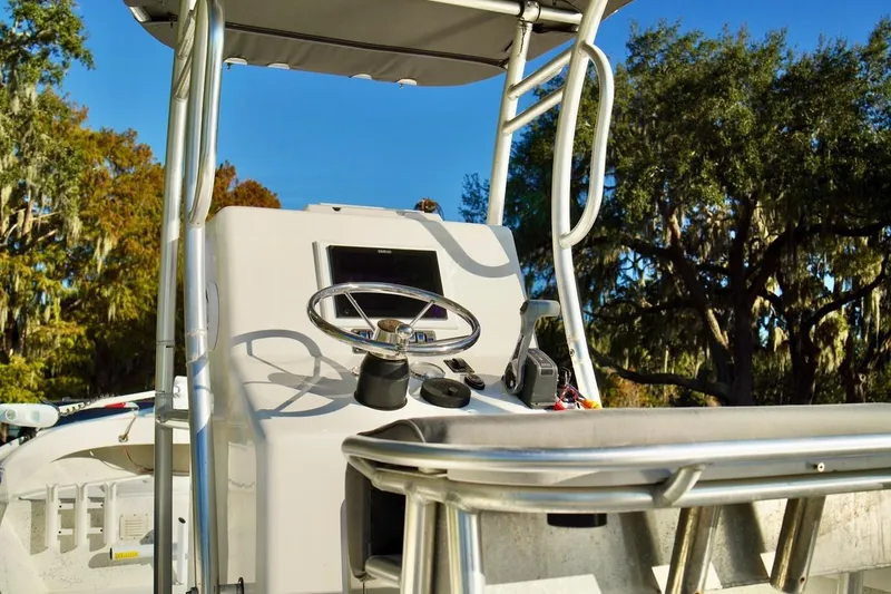 Slide: The Image of 1970 Aquasport 222 Flatback boat console with steering wheel, set against a scenic backdrop. - 12